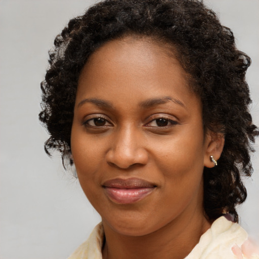 Joyful black young-adult female with medium  brown hair and brown eyes