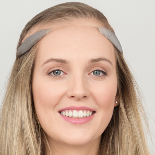 Joyful white young-adult female with long  brown hair and blue eyes