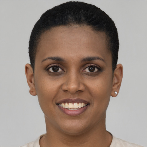Joyful black young-adult female with short  black hair and brown eyes