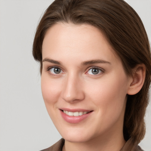 Joyful white young-adult female with medium  brown hair and grey eyes