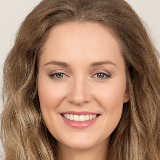 Joyful white young-adult female with long  brown hair and brown eyes