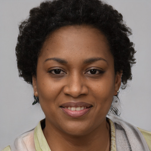 Joyful black young-adult female with short  brown hair and brown eyes