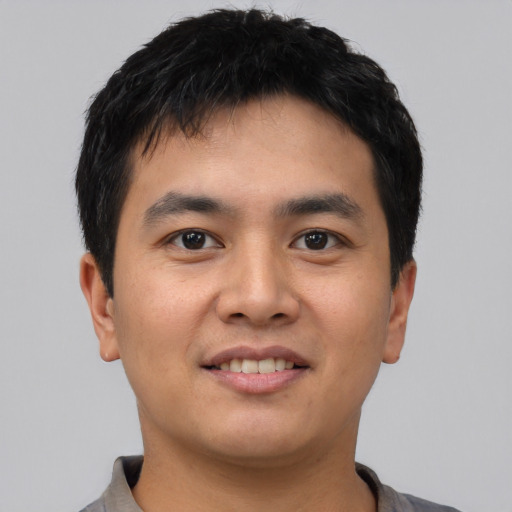 Joyful asian young-adult male with short  black hair and brown eyes