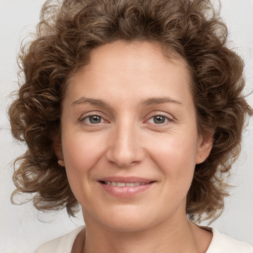 Joyful white young-adult female with medium  brown hair and green eyes