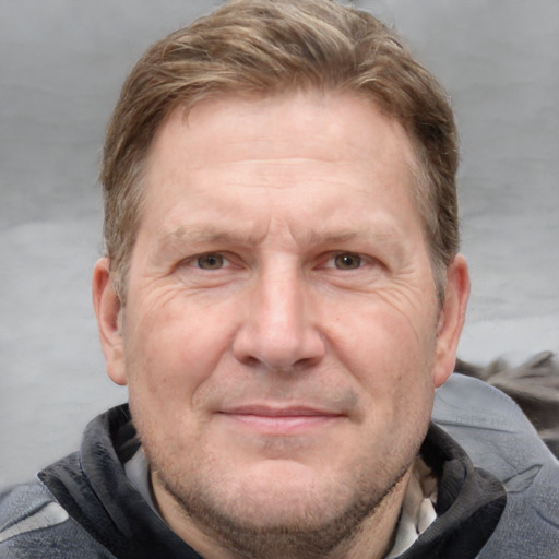 Joyful white adult male with short  brown hair and blue eyes