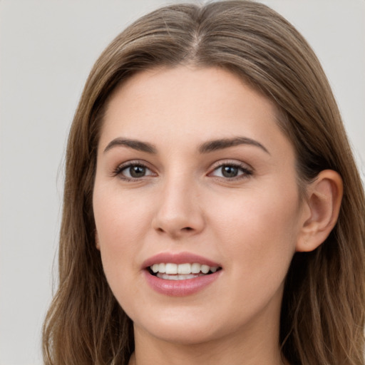 Joyful white young-adult female with long  brown hair and grey eyes