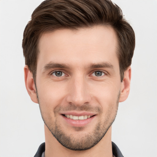 Joyful white young-adult male with short  brown hair and grey eyes