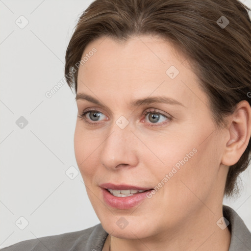 Joyful white young-adult female with medium  brown hair and grey eyes