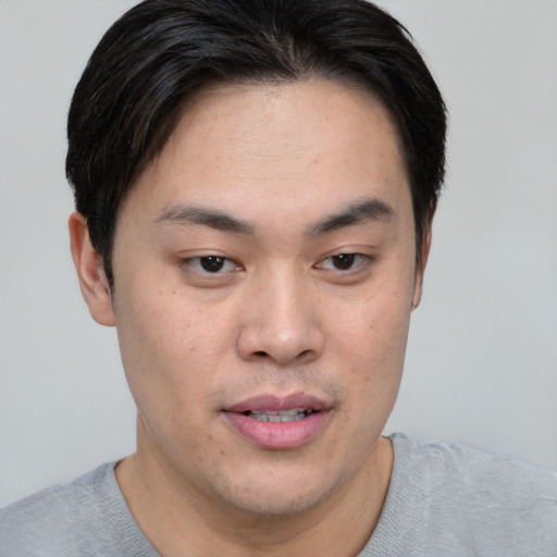 Joyful asian young-adult male with short  brown hair and brown eyes