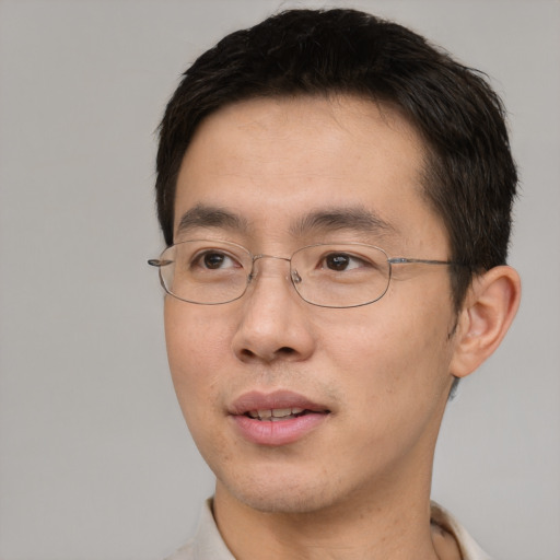 Joyful asian adult male with short  brown hair and brown eyes