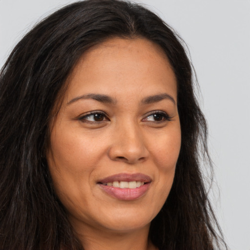 Joyful latino young-adult female with long  brown hair and brown eyes