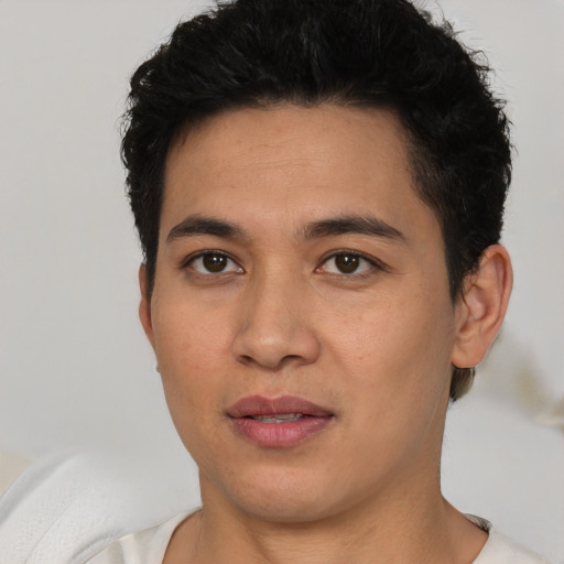 Joyful latino young-adult male with short  brown hair and brown eyes