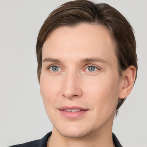 Joyful white young-adult male with short  brown hair and grey eyes