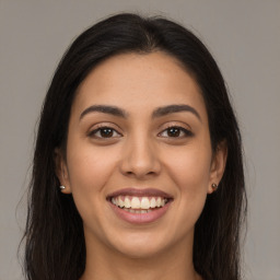 Joyful latino young-adult female with long  brown hair and brown eyes