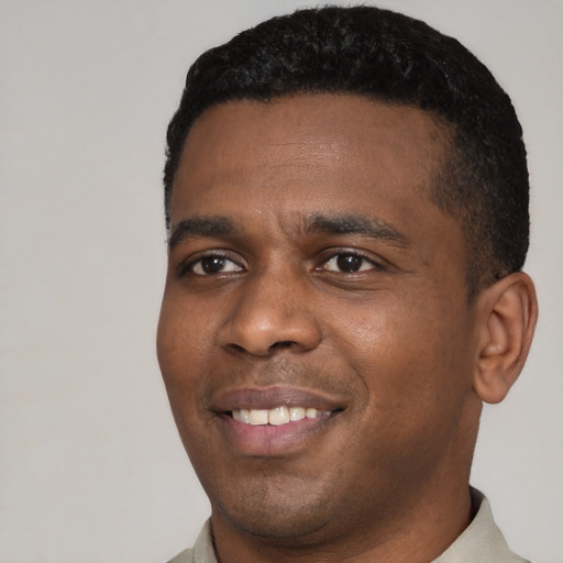 Joyful black young-adult male with short  black hair and brown eyes