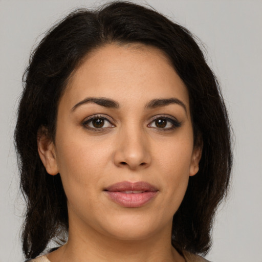 Joyful latino young-adult female with medium  brown hair and brown eyes