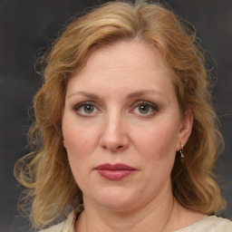 Joyful white adult female with medium  brown hair and blue eyes
