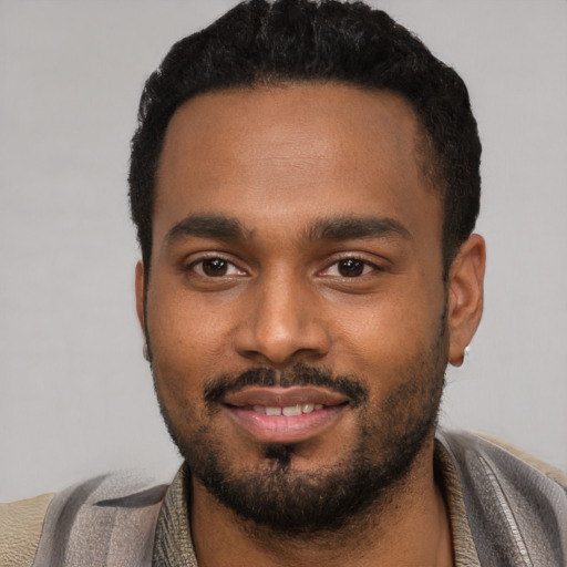 Joyful black young-adult male with short  black hair and brown eyes