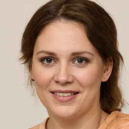 Joyful white young-adult female with medium  brown hair and green eyes