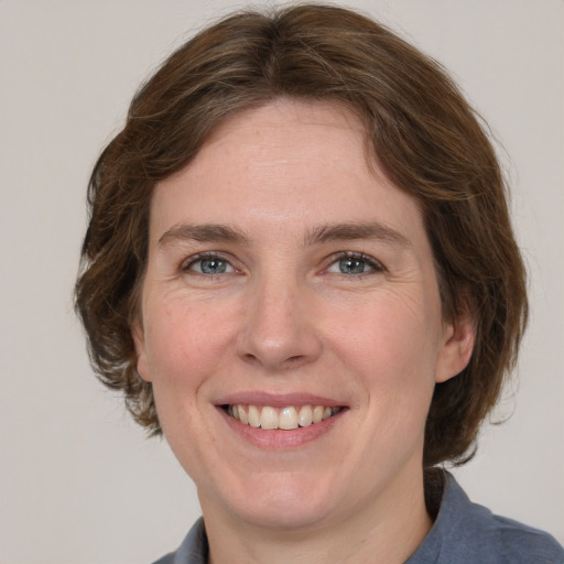 Joyful white adult female with medium  brown hair and grey eyes