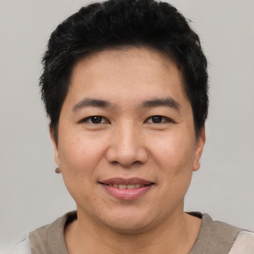 Joyful asian young-adult male with short  black hair and brown eyes