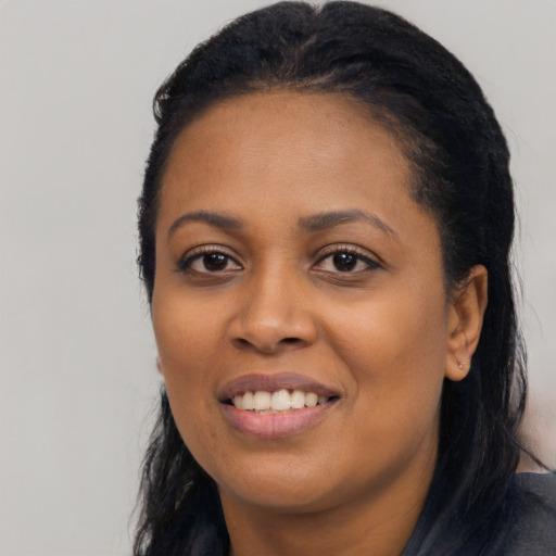 Joyful black young-adult female with long  black hair and brown eyes
