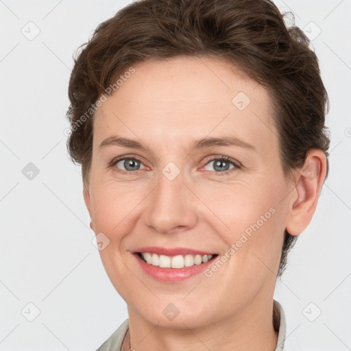 Joyful white young-adult female with short  brown hair and grey eyes