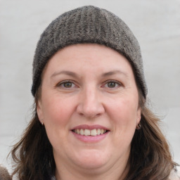 Joyful white adult female with medium  brown hair and grey eyes