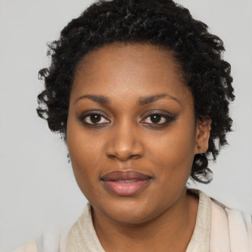 Joyful black young-adult female with long  black hair and brown eyes