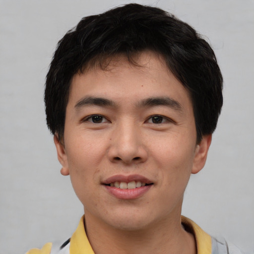 Joyful asian young-adult male with short  brown hair and brown eyes