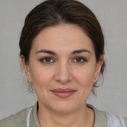 Joyful white adult female with medium  brown hair and brown eyes