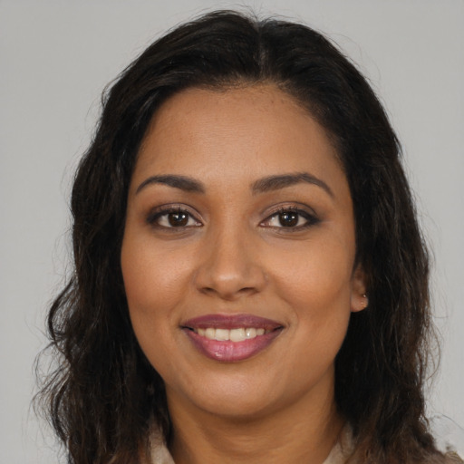 Joyful black young-adult female with long  brown hair and brown eyes
