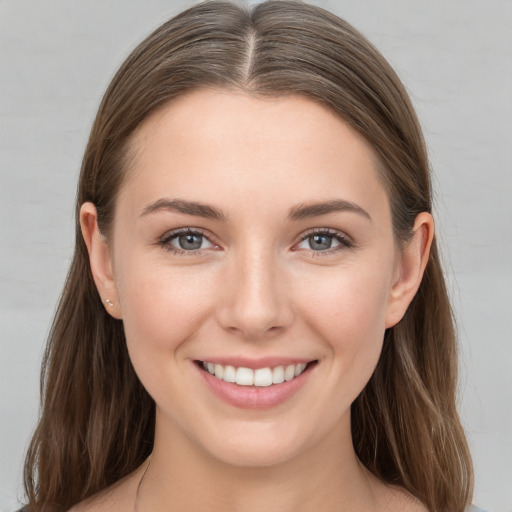 Joyful white young-adult female with long  brown hair and grey eyes