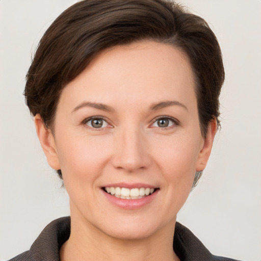 Joyful white young-adult female with short  brown hair and grey eyes