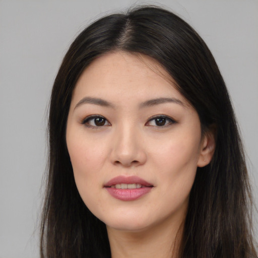 Joyful asian young-adult female with long  brown hair and brown eyes
