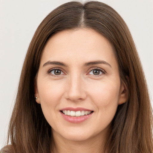 Joyful white young-adult female with long  brown hair and brown eyes