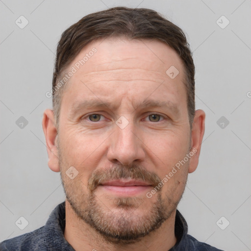 Joyful white adult male with short  brown hair and grey eyes