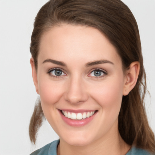 Joyful white young-adult female with long  brown hair and grey eyes