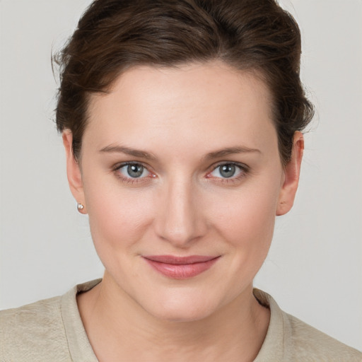 Joyful white young-adult female with short  brown hair and grey eyes