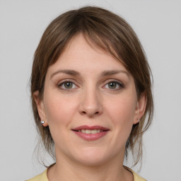 Joyful white young-adult female with medium  brown hair and grey eyes