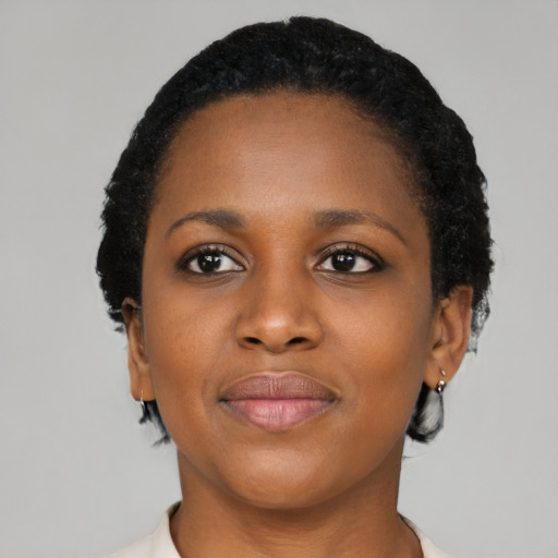 Joyful black young-adult female with short  black hair and brown eyes