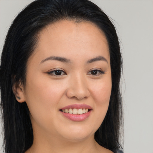 Joyful asian young-adult female with long  brown hair and brown eyes