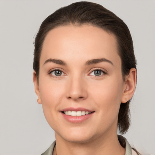 Joyful white young-adult female with medium  brown hair and grey eyes