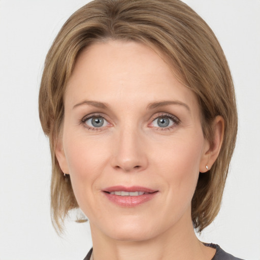 Joyful white adult female with medium  brown hair and grey eyes