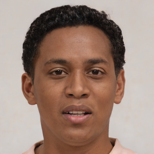 Joyful black young-adult male with short  brown hair and brown eyes