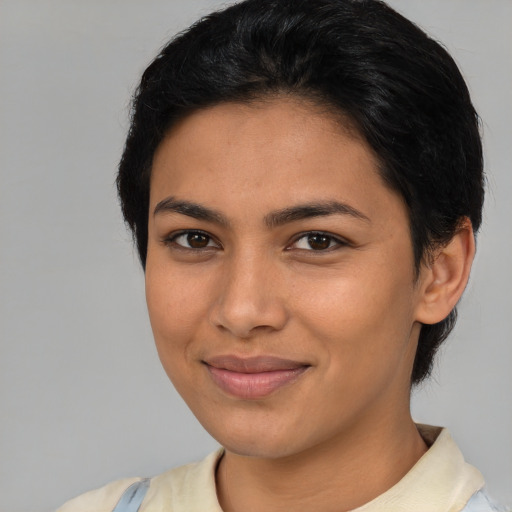 Joyful latino young-adult female with short  brown hair and brown eyes