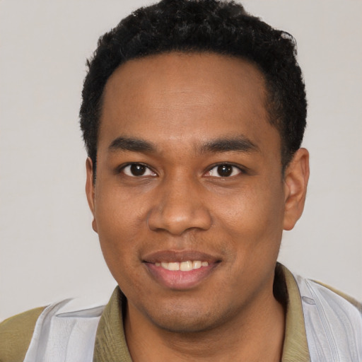 Joyful black young-adult male with short  black hair and brown eyes