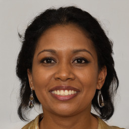 Joyful black adult female with medium  brown hair and brown eyes