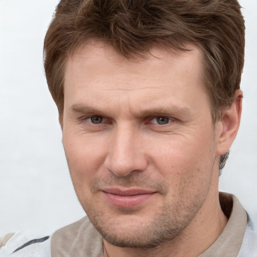 Joyful white adult male with short  brown hair and grey eyes