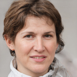 Joyful white adult female with medium  brown hair and grey eyes